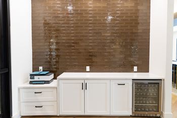 A kitchen with a white cabinet and a brown tiled wall at The Crest at South Point Apartments, Davenport  30253